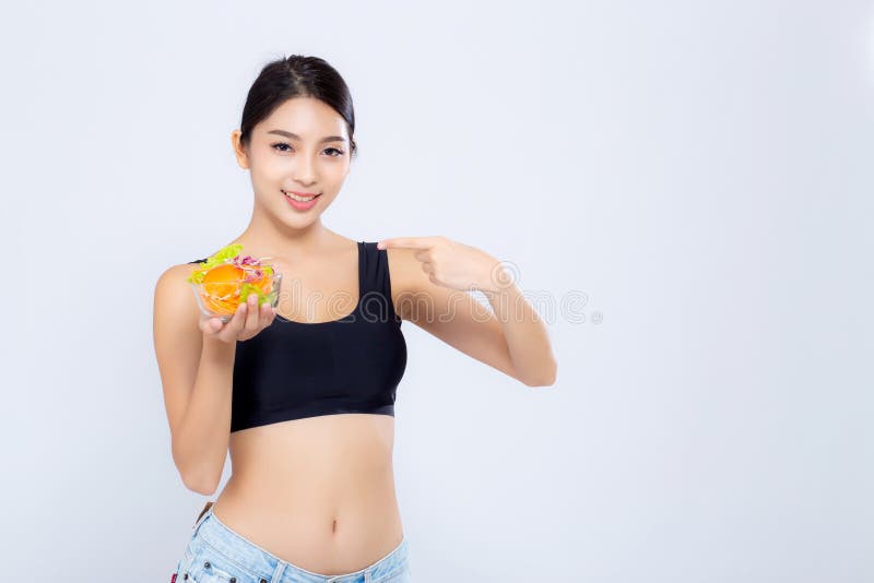Participation de sourire de belle femme asiatique de portrait jeune et pointage de la nourriture de l?gume de salade d'isolement photo stock Participation de sourire de belle femme asiatique de portrait jeune et pointage de la nourriture de l?gume de salade d'isolement photo stock
