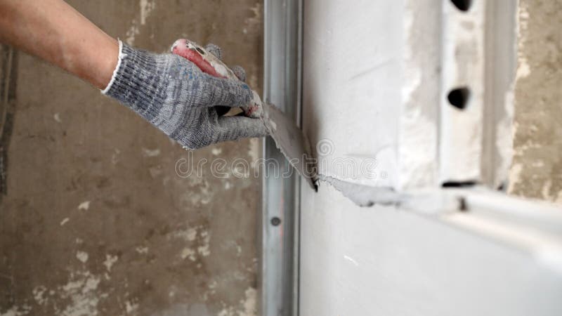 A mason applies cement adhesive to a brick when constructing an interior wall. Partition made of tongue-and-groove slabs. A mason applies cement adhesive to a brick when constructing an interior wall. Partition made of tongue-and-groove slabs.