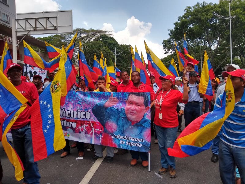 Partidarios de la marcha de Nicolas Maduro en Caracas para conmemorar el primer aniversario de la reelección fotos de archivo Partidarios de la marcha de Nicolas Maduro en Caracas para conmemorar el primer aniversario de la reelección fotos de archivo