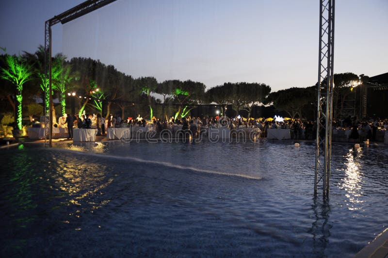 Partido de cena por la piscina en la puesta del sol imagen de archivo Partido de cena por la piscina en la puesta del sol imagen de archivo