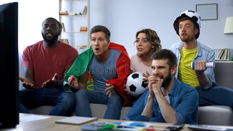 Partido de fútbol de observación de los amigos multiétnicos de Portugal en casa, apoyando al equipo imagen de archivo libre de regalías Partido de fútbol de observación de los amigos multiétnicos de Portugal en casa, apoyando al equipo imagen de archivo libre de regalías