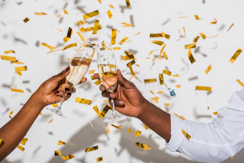partisk sikt för närbild av afrikansk amerikanpar som klirrar exponeringsglas av champagne på vit arkivfoton partisk sikt för närbild av afrikansk amerikanpar som klirrar exponeringsglas av champagne på vit arkivfoton