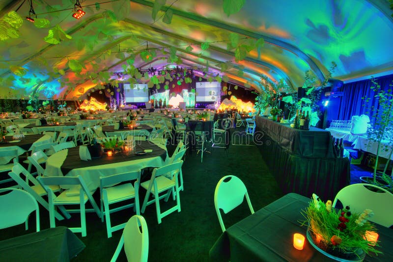 A large group of 800 people party room table set inside a tent with bars. A large group of 800 people party room table set inside a tent with bars