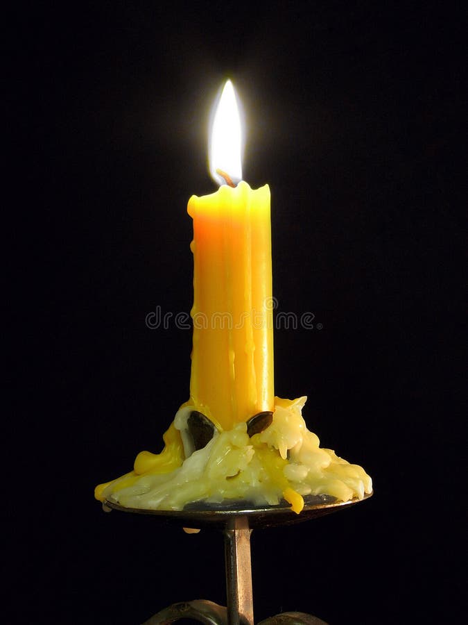 Partly Melted Candle Burning on a Black Background Stock Photo Image