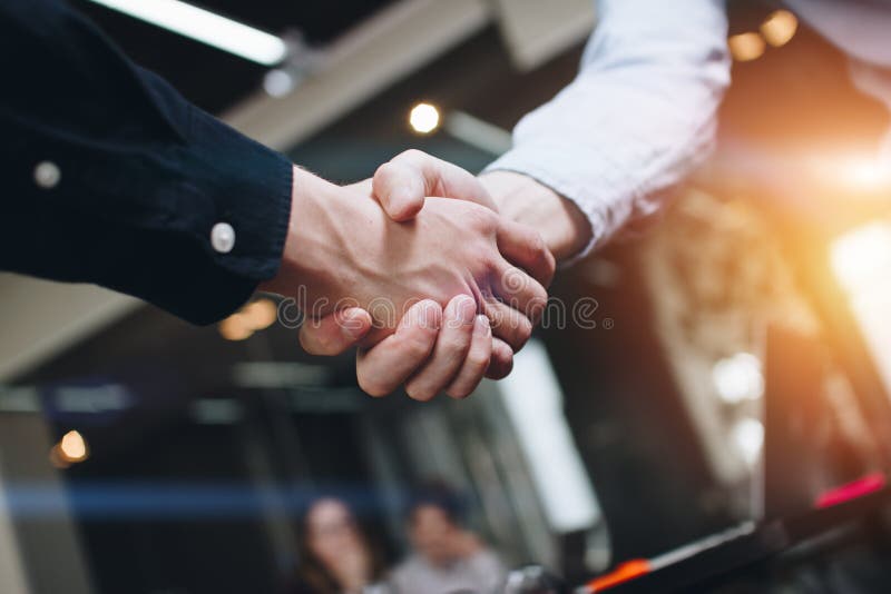 Partnerów biznesowych uściski dłoni w nowożytnej otwartej przestrzeni na tle coworking drużyna na nowym początkowym projekcie zdjęcie stock