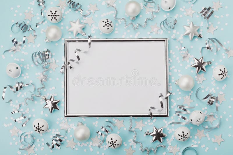 Party carnival christmas background decorated silver frame with confetti, balls and star on turquoise desk top view. Flat lay.