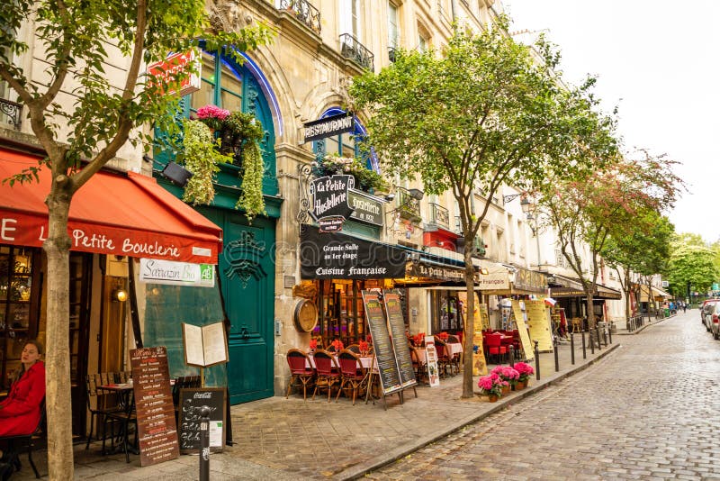 Pary?, Francja - 24 04 2019: Łaciny ćwiartka Wąska ulica Paryż wśród starych tradycyjnych parisian domów wewnątrz i kawiarni zdjęcia stock Pary?, Francja - 24 04 2019: Łaciny ćwiartka Wąska ulica Paryż wśród starych tradycyjnych parisian domów wewnątrz i kawiarni zdjęcia stock