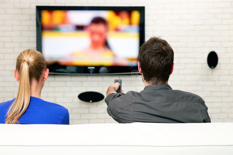 Couple watching tv sat on the sofa. Couple watching tv sat on the sofa