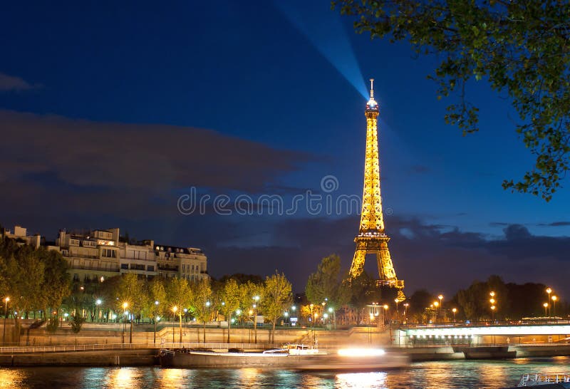 PARIS - August 1: Seine Embankment and Eiffel tower at night on August 1, 2012 in Paris. Eiffel tower is the most visited monument of France. PARIS - August 1: Seine Embankment and Eiffel tower at night on August 1, 2012 in Paris. Eiffel tower is the most visited monument of France