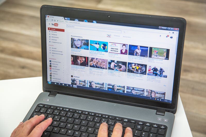 París, Francia - 27 de enero de 2017: Hombre que usa un ordenador portátil para conectar con el Home Page del sitio web de YouTub imagen de archivo libre de regalías París, Francia - 27 de enero de 2017: Hombre que usa un ordenador portátil para conectar con el Home Page del sitio web de YouTub imagen de archivo libre de regalías