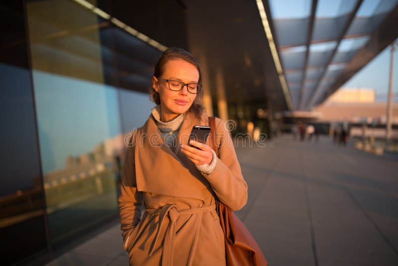 Pasajero femenino joven en el aeropuerto, usando su tableta fotografía de archivo Pasajero femenino joven en el aeropuerto, usando su tableta fotografía de archivo