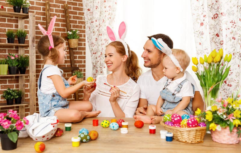 ¡Pascua feliz! la madre, el padre y los niños de la familia pintan los huevos para imagen de archivo libre de regalías ¡Pascua feliz! la madre, el padre y los niños de la familia pintan los huevos para imagen de archivo libre de regalías