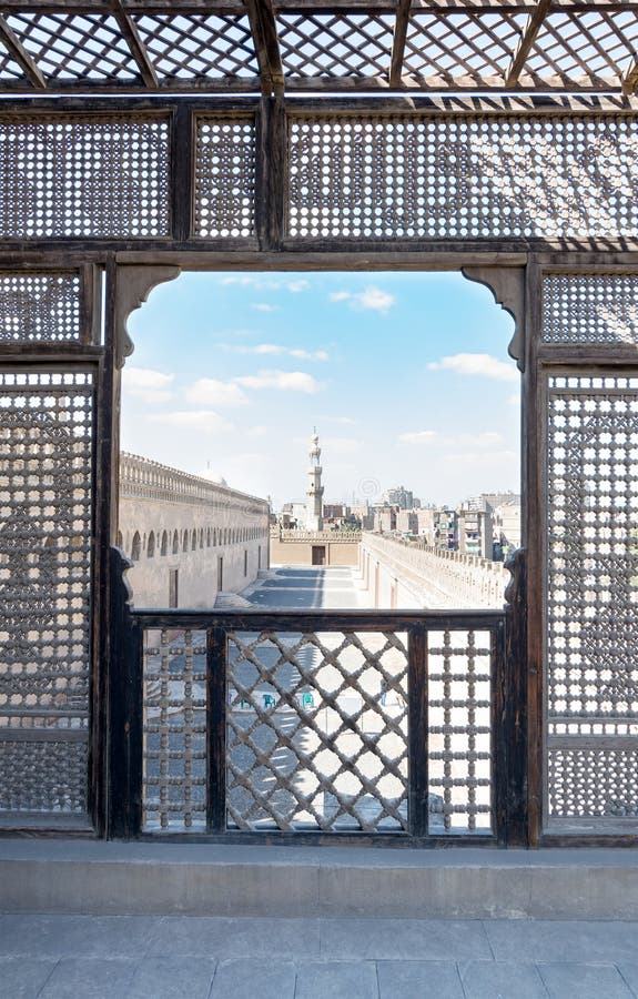 Pase rodeando la mezquita de Ibn Tulun enmarcó por la pared perforada de madera interpolada Mashrabiya imagenes de archivo Pase rodeando la mezquita de Ibn Tulun enmarcó por la pared perforada de madera interpolada Mashrabiya imagenes de archivo