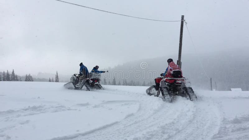 Paseo del grupo de personas en la moto de nieve