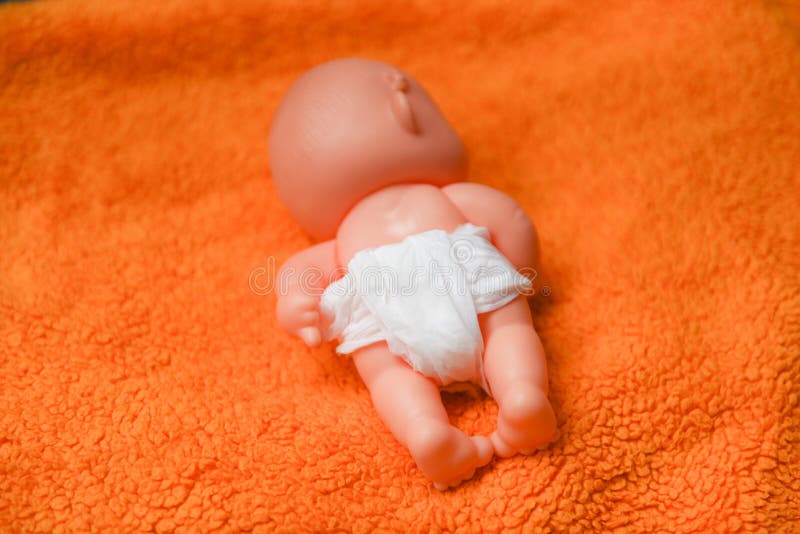 Pasgeboren baby met Luiers - babystuk speelgoed slijtage witte luier en het spelen op een oranje gebreide deken in het kinderdagv royalty-vrije stock fotografie Pasgeboren baby met Luiers - babystuk speelgoed slijtage witte luier en het spelen op een oranje gebreide deken in het kinderdagv royalty-vrije stock fotografie