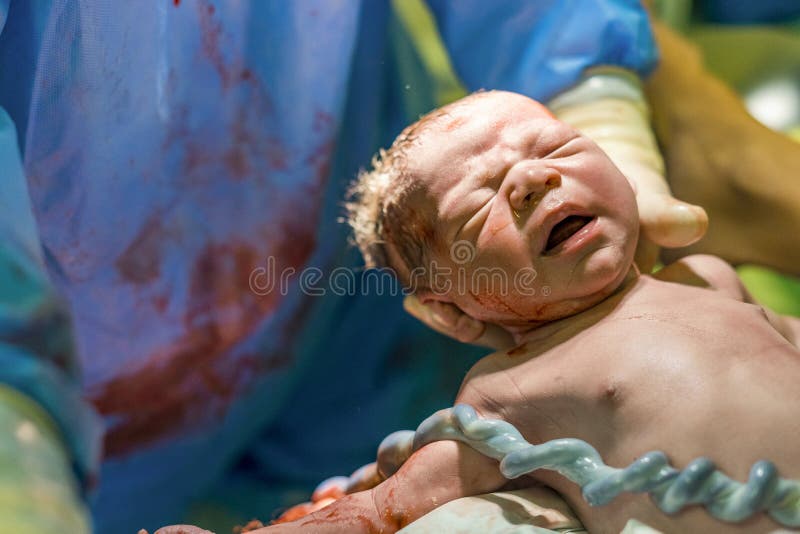 Pasgeboren babyjongen bijgestaan door vroedvrouw royalty-vrije stock foto Pasgeboren babyjongen bijgestaan door vroedvrouw royalty-vrije stock foto