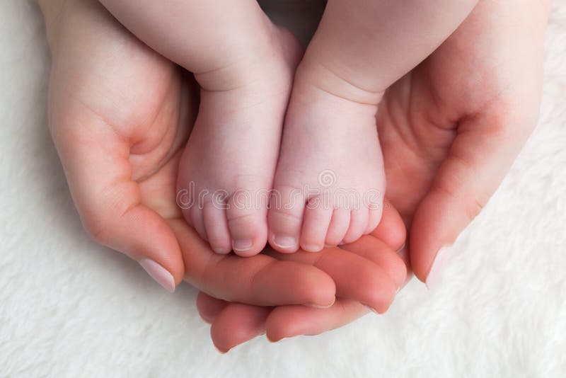 Pasgeboren babyvoeten in de handen van de moeder De kinderverzorging, veilig voelen, beschermt stock afbeelding Pasgeboren babyvoeten in de handen van de moeder De kinderverzorging, veilig voelen, beschermt stock afbeelding