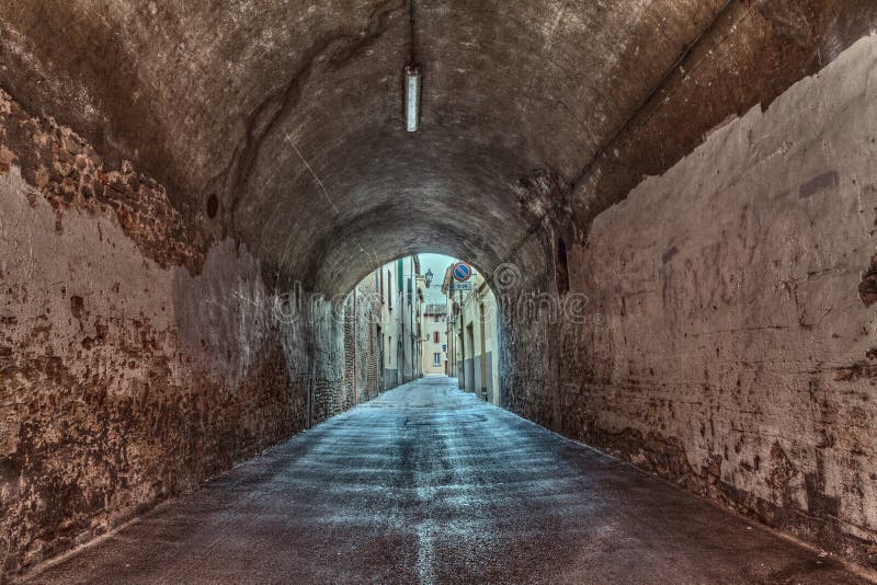 Dark narrow underpass in the old town - urban decay, grunge alley in Italy. Dark narrow underpass in the old town - urban decay, grunge alley in Italy