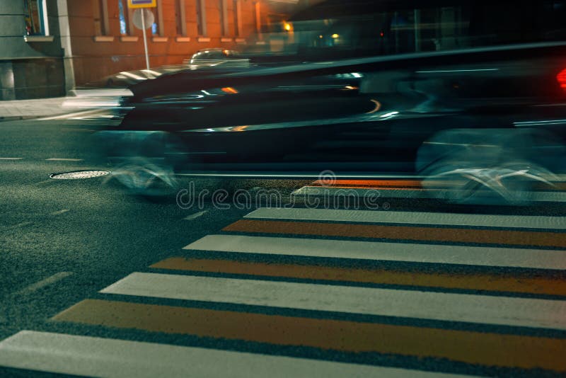 Crosswalk in city with fast moving blurred car at night. Pedestrian safety concept. Crosswalk in city with fast moving blurred car at night. Pedestrian safety concept.