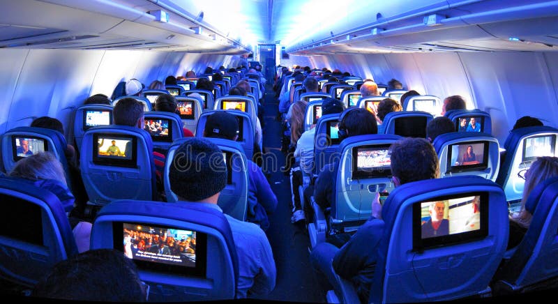Passageiros do avião, assentos e telas da tevê