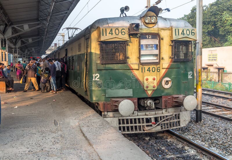 Passageiros indianos do embarque do trem local da manhã das estradas de ferro em uma estação imagens de stock Passageiros indianos do embarque do trem local da manhã das estradas de ferro em uma estação imagens de stock