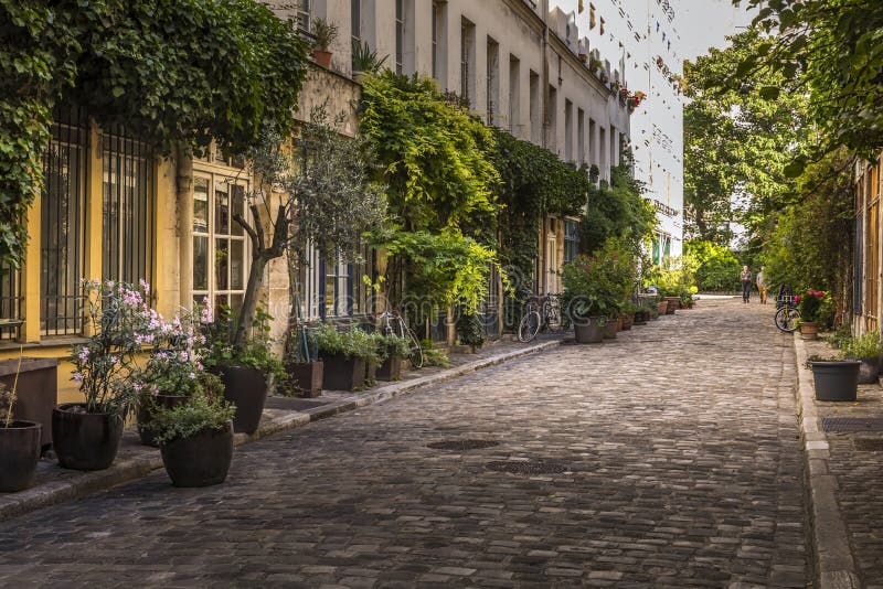 Paris, France - June 24, 2020: Passage Lhomme with its vegetation and its old workshops in Paris 11th district. Paris, France - June 24, 2020: Passage Lhomme with its vegetation and its old workshops in Paris 11th district