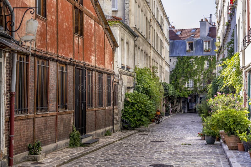 Paris, France - June 24, 2020: Passage Lhomme with its vegetation and its old workshops in Paris 11th district. Paris, France - June 24, 2020: Passage Lhomme with its vegetation and its old workshops in Paris 11th district