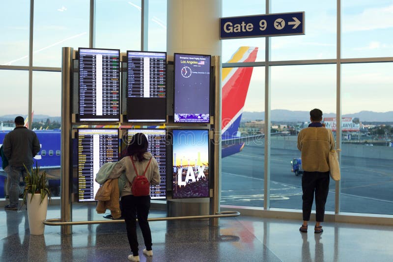 Southwest Airline passengers consult flight information board and watch planes from Los Angeles departure gate. Southwest Airline passengers consult flight information board and watch planes from Los Angeles departure gate