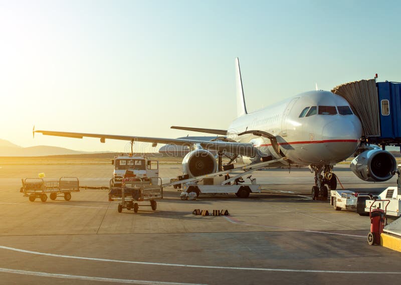 Passagiersvliegtuig in de luchthaven bij zonsopgang stock fotografie Passagiersvliegtuig in de luchthaven bij zonsopgang stock fotografie