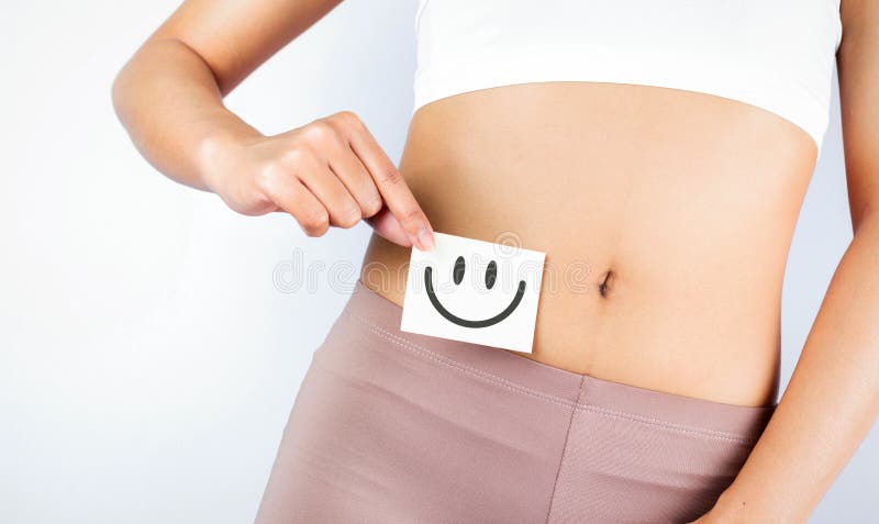 Passande tunn kropp som håller vitt kort med glad smiley ansikte i händerna goda matsmältningsbegrepp