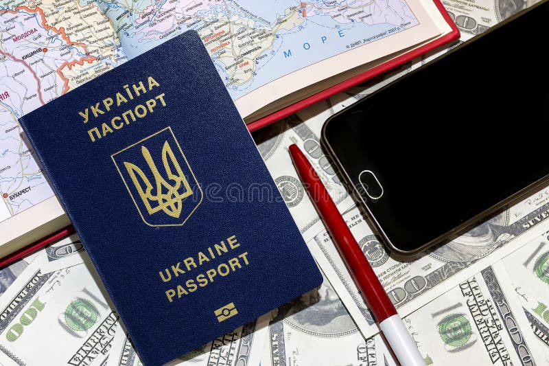 Passaporto ucraino sui precedenti delle fatture del cento-dollaro con un telefono e una carta fotografia stock libera da diritti Passaporto ucraino sui precedenti delle fatture del cento-dollaro con un telefono e una carta fotografia stock libera da diritti