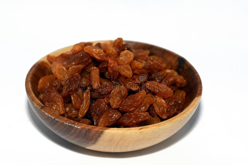 Dried raisins in a brown wooden bowl  on a white background, Egyptian raisins, A raisin is a dried grape. Raisins are produced in many regions of the world and may be eaten raw or used in cooking, baking, and brewing. In the United Kingdom, Ireland, New Zealand, and Australia, the word raisin is reserved for the dark-colored dried large grape, with sultana being a golden-colored dried grape, and currant being a dried small Black Corinth seedless grape. Dried raisins in a brown wooden bowl  on a white background, Egyptian raisins, A raisin is a dried grape. Raisins are produced in many regions of the world and may be eaten raw or used in cooking, baking, and brewing. In the United Kingdom, Ireland, New Zealand, and Australia, the word raisin is reserved for the dark-colored dried large grape, with sultana being a golden-colored dried grape, and currant being a dried small Black Corinth seedless grape.