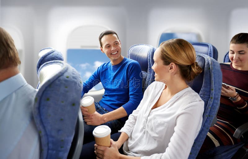 Passeggeri felici con caffè che parlano in aereo