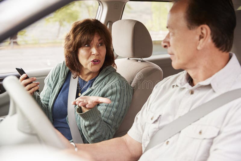 Passeggero della donna in automobile con lo smartphone che parla con autista fotografie stock Passeggero della donna in automobile con lo smartphone che parla con autista fotografie stock