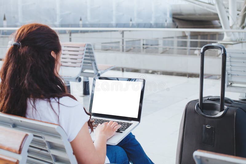 Passeggero della donna che utilizza computer portatile nell'aeroporto, contando online o nella registrazione di web immagine stock libera da diritti Passeggero della donna che utilizza computer portatile nell'aeroporto, contando online o nella registrazione di web immagine stock libera da diritti