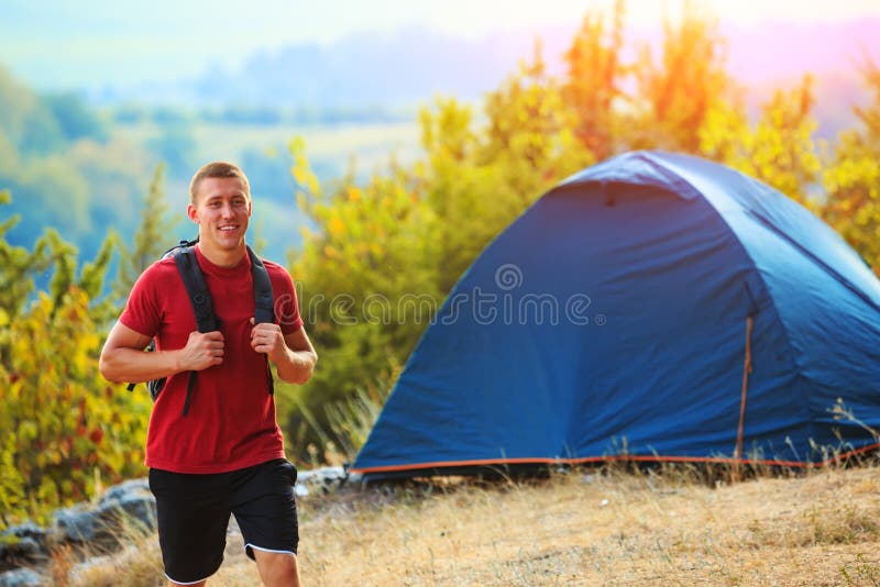 Passeggiata degli uomini lungo la collina con lo zaino fotografia stock libera da diritti Passeggiata degli uomini lungo la collina con lo zaino fotografia stock libera da diritti