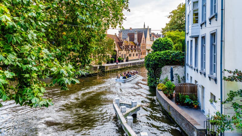 Passeio do barco de canal no canal de Groenerei no coração da cidade medieval de Bruges, Bélgica imagem de stock royalty free Passeio do barco de canal no canal de Groenerei no coração da cidade medieval de Bruges, Bélgica imagem de stock royalty free