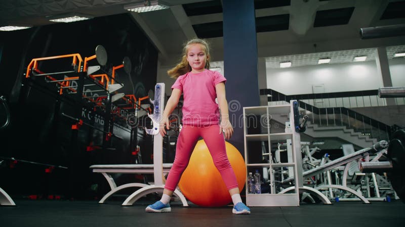 Passend atletisch meisje werkt uit op het uitproberen van haar fitness. opleiding van kinderen in moderne gym.