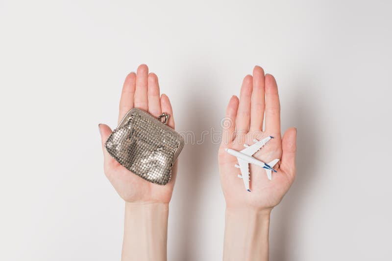 Passenger plane and wallet on female palms on a light background. Cheap flights.