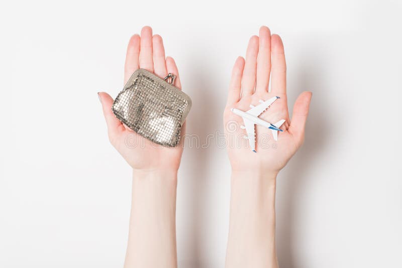 Passenger plane and wallet on female palms on a light background. Cheap flights.