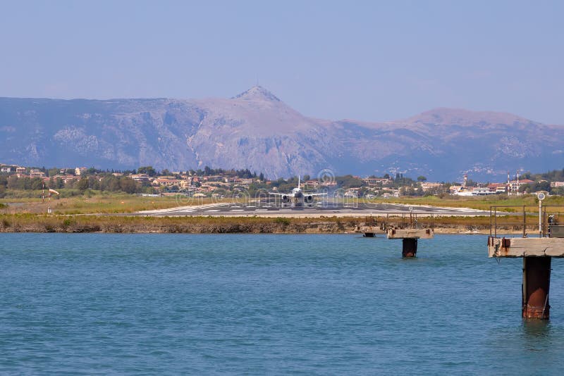 Passenger`s airplane is landing at Kerkyra Airport. Greece, Corfu island. Decrease in height. Runway on the background of mountains and sea. Airplane height stock images, royalty-free photos and pictures
