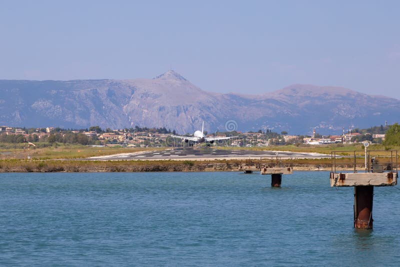 Passenger`s airplane is landing at Kerkyra Airport. Greece, Corfu island. Decrease in height. Runway on the background of mountains and sea. Airplane height stock images, royalty-free photos and pictures