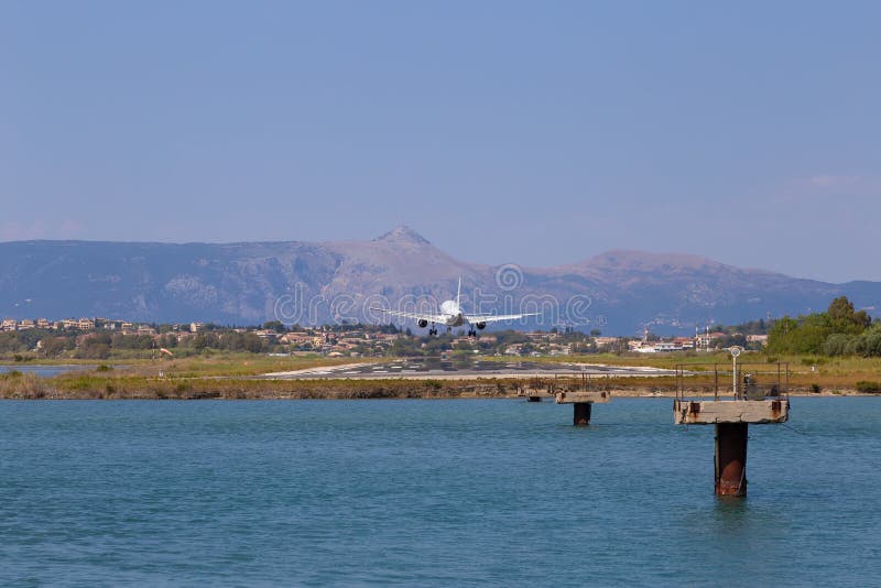Passenger`s airplane is landing at Kerkyra Airport. Greece, Corfu island. Decrease in height. Runway on the background of mountains and sea. Airplane height stock images, royalty-free photos and pictures