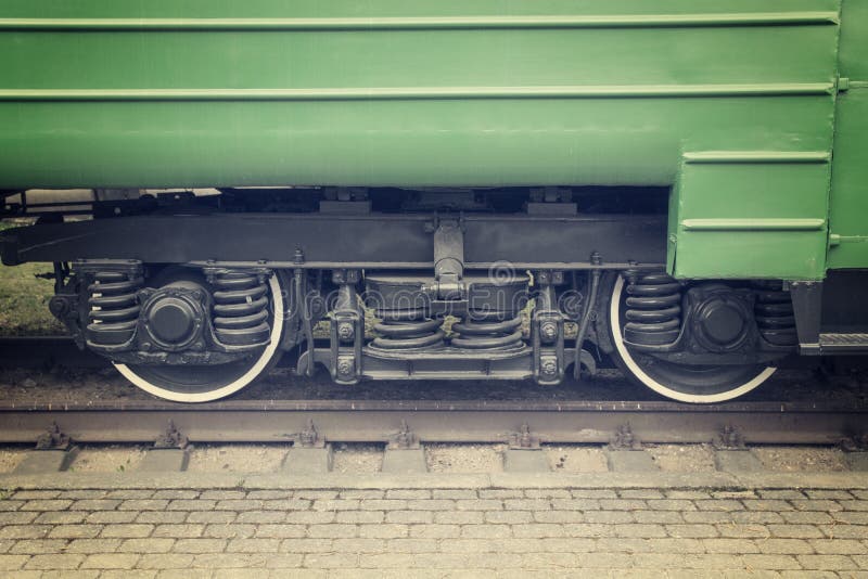 Green color passenger train wheels close up