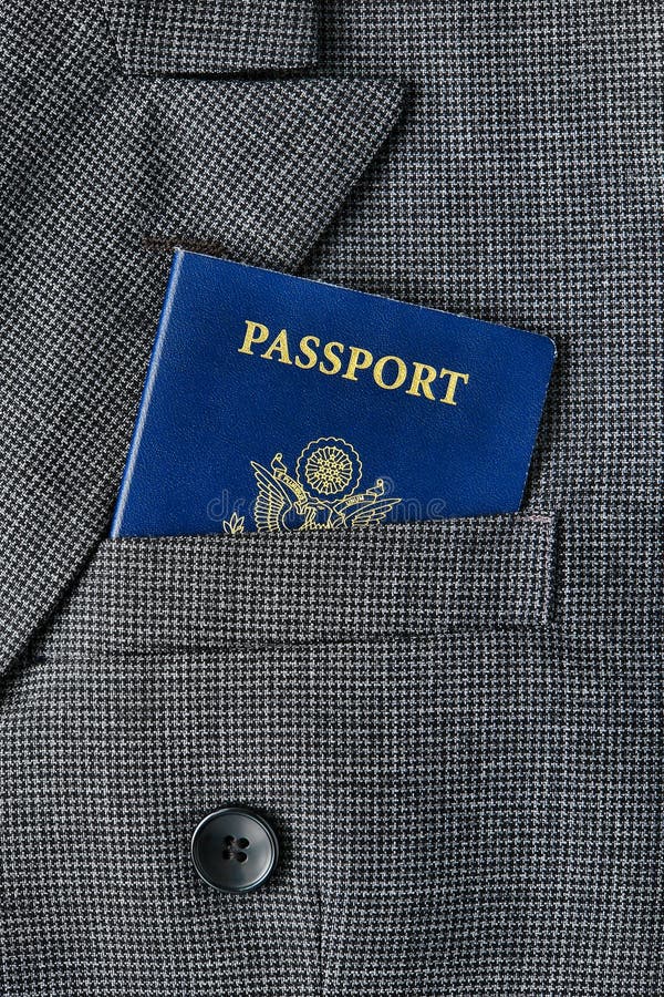 United States of America US citizenship passport book in an American executive business man suit jacket breast pocket for a corporate trip abroad. United States of America US citizenship passport book in an American executive business man suit jacket breast pocket for a corporate trip abroad