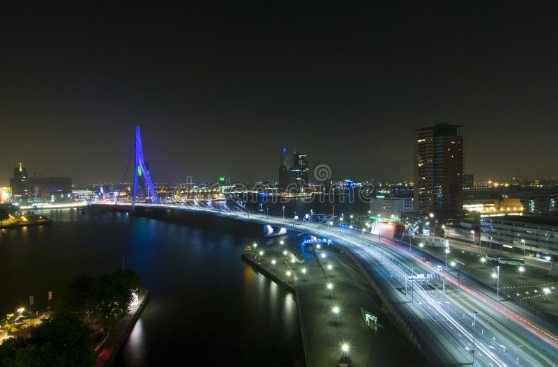 The Rotterdam Skyline with the famous Erasmus Bridge over the river Meuze at night See more images that illustrate. The Rotterdam Skyline with the famous Erasmus Bridge over the river Meuze at night See more images that illustrate