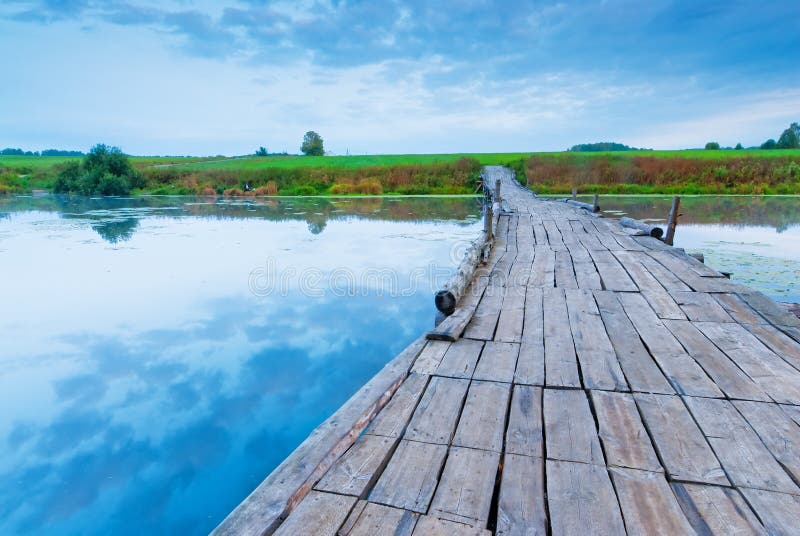 Passerelle en bois au-dessus d'un petit lac images stock Passerelle en bois au-dessus d'un petit lac images stock