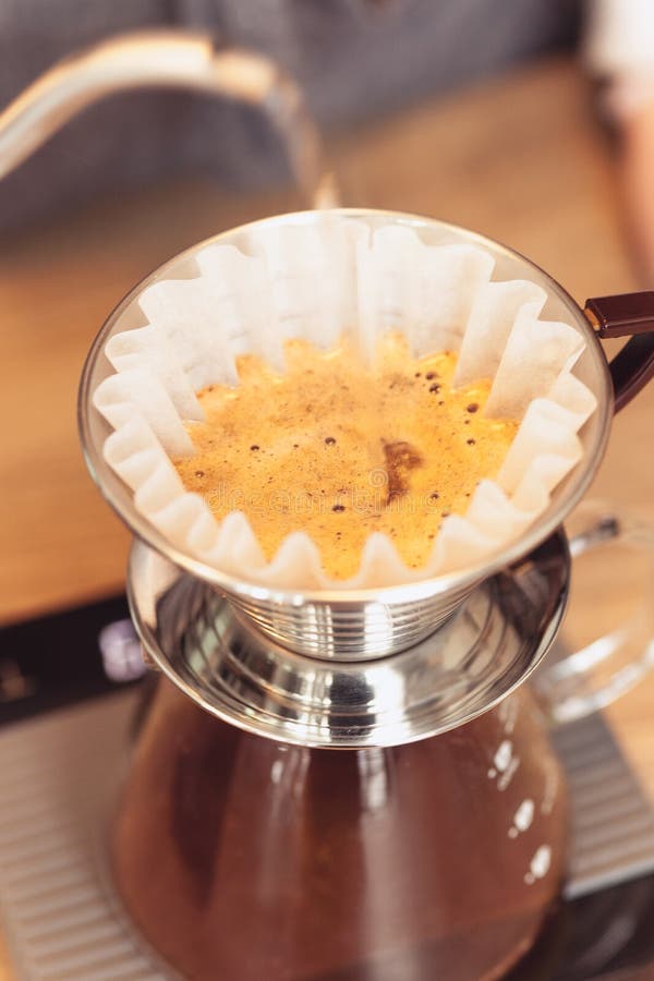 Passi il caffè americano, l'acqua di versamento di barista sul fondo di caffè con il filtro fotografie stock libere da diritti Passi il caffè americano, l'acqua di versamento di barista sul fondo di caffè con il filtro fotografie stock libere da diritti