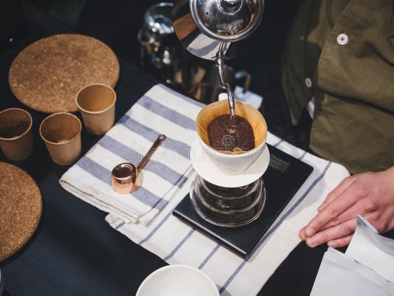 Passi l'acqua di versamento di barista del caffè americano sul fondo di caffè con fil fotografia stock libera da diritti Passi l'acqua di versamento di barista del caffè americano sul fondo di caffè con fil fotografia stock libera da diritti