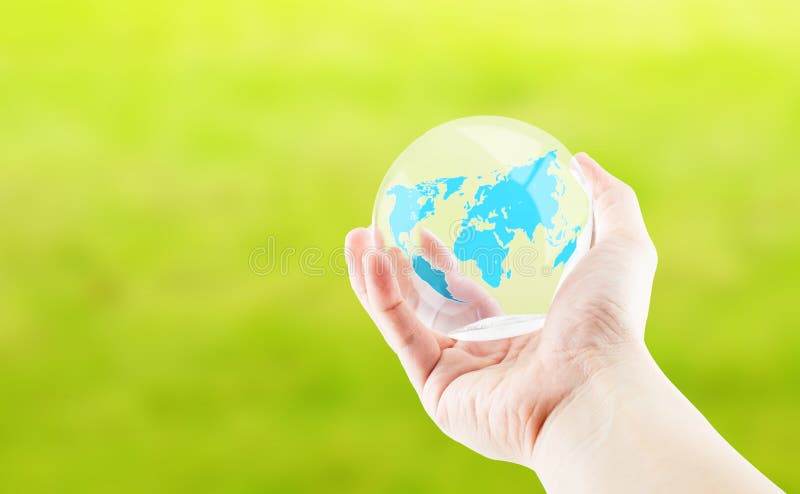 Passi la tenuta intorno alla palla lucida con la mappa di mondo su backgroun verde fotografie stock Passi la tenuta intorno alla palla lucida con la mappa di mondo su backgroun verde fotografie stock
